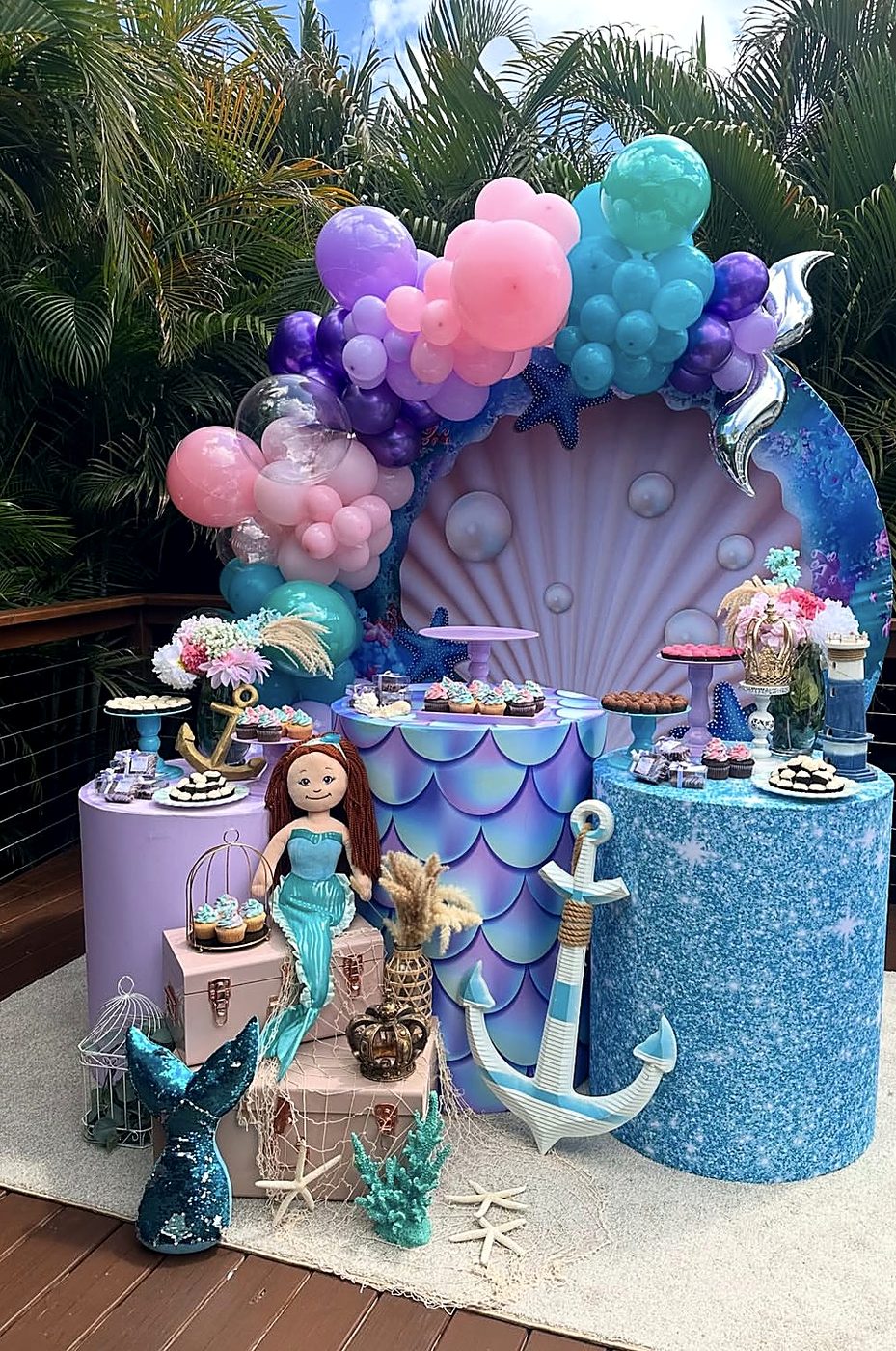 Outdoor mermaid party with seashell backdrop and dessert table
